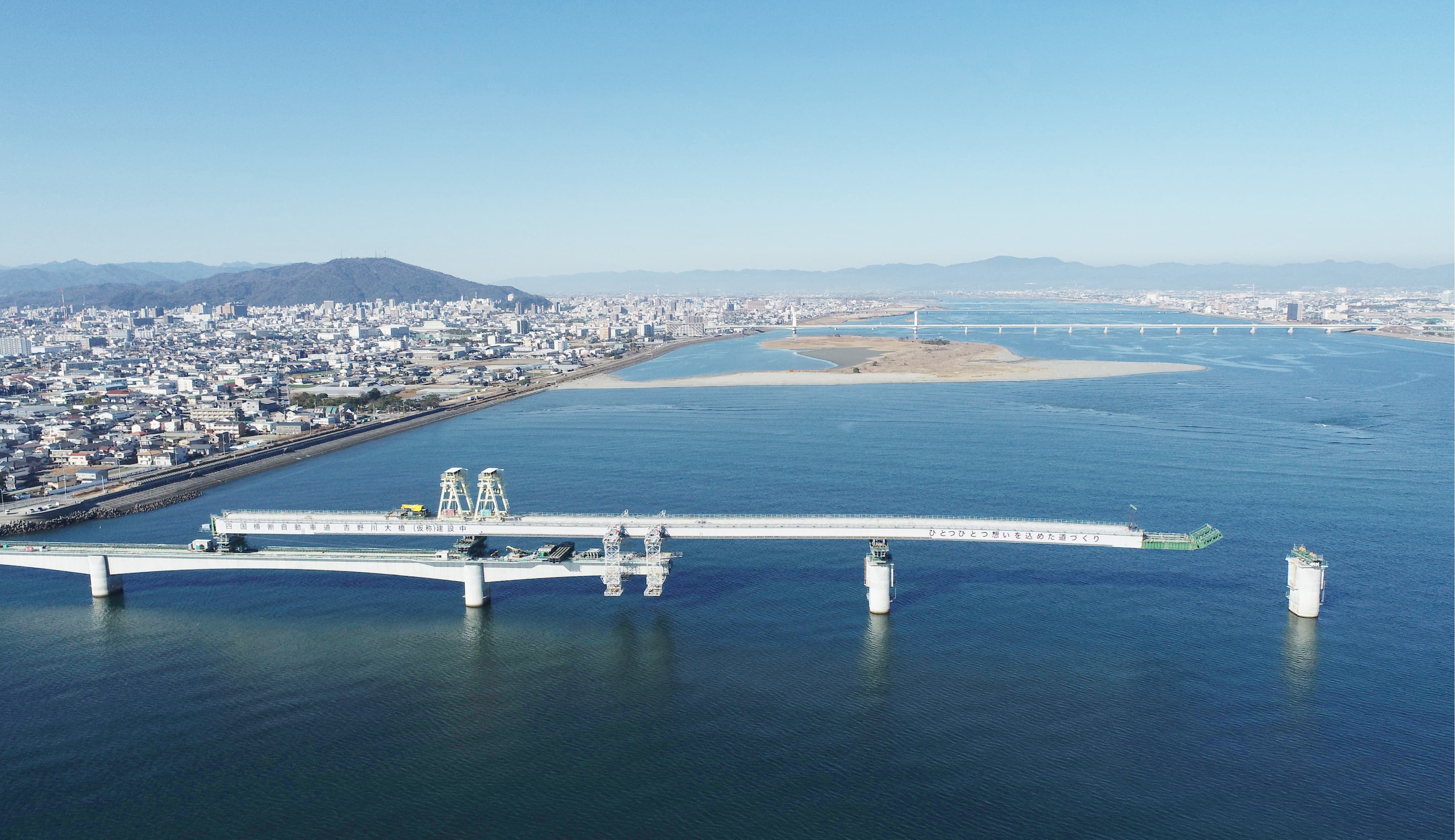 補助桁併用張出架設（河川上空から補助桁による資材搬入）